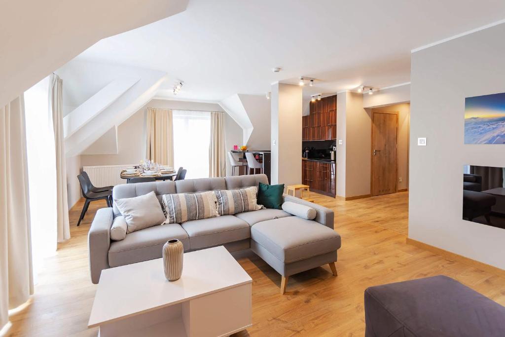 salon z kanapą i stołem w obiekcie VacationClub - Rezydencja Karkonoska Apartament 10 w mieście Karpacz