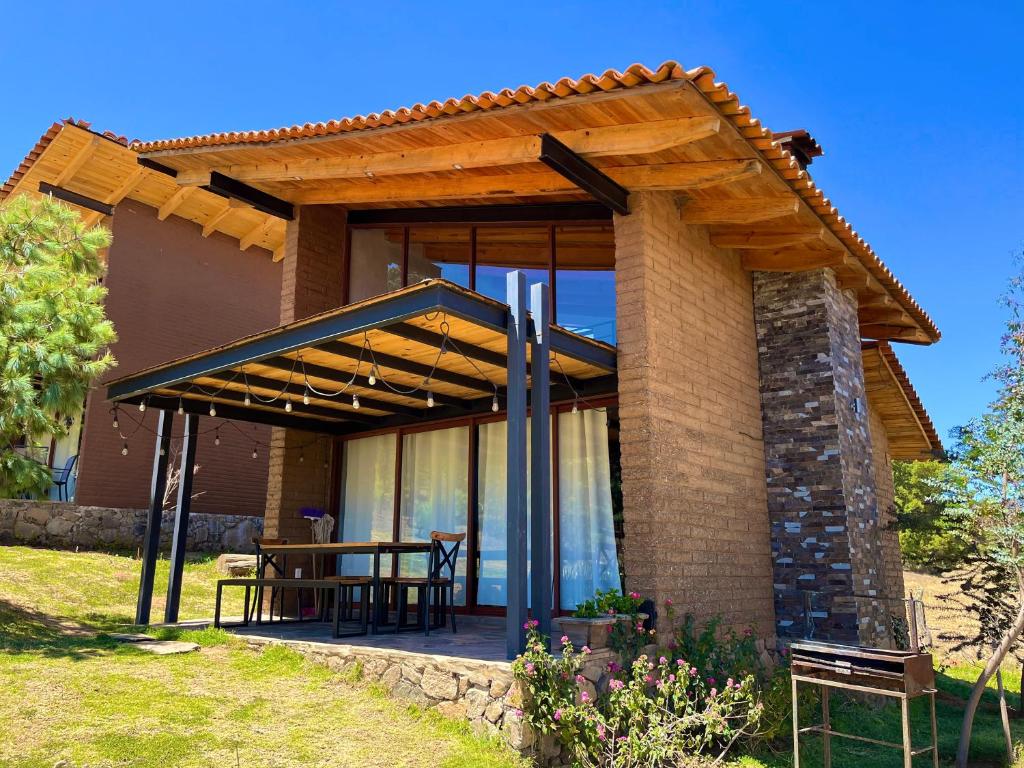 a house with a patio with a table on it at Cabaña Oso Tapalpa in Tapalpa