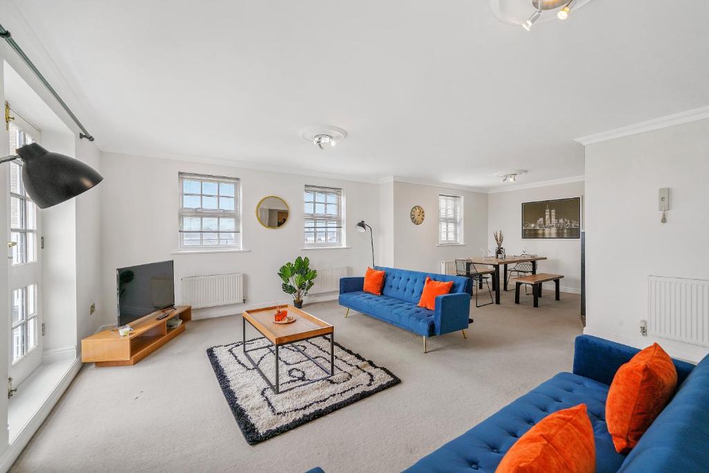 a living room with blue couches and a table at Stylish Central York Duplex Penthouse in York