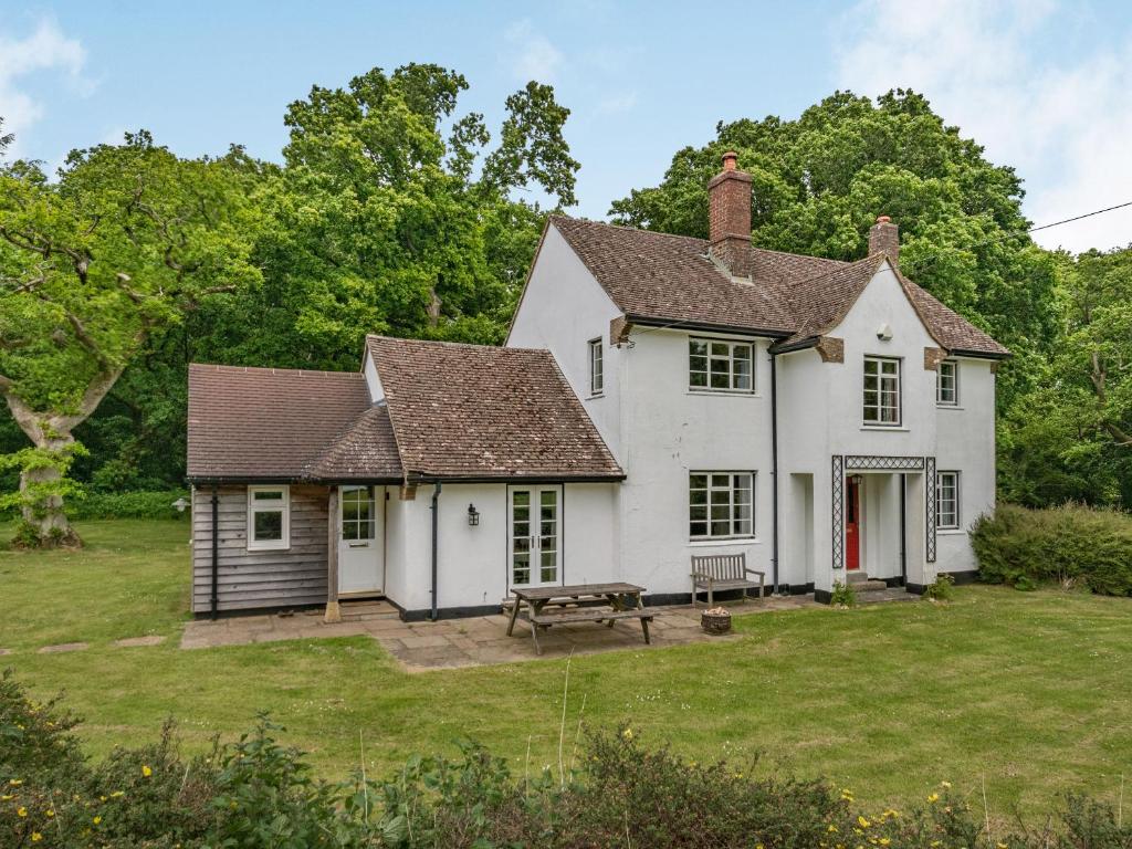 Biały dom ze stołem piknikowym na dziedzińcu w obiekcie Chasewoods Farm Cottage w mieście Ogbourne Saint George