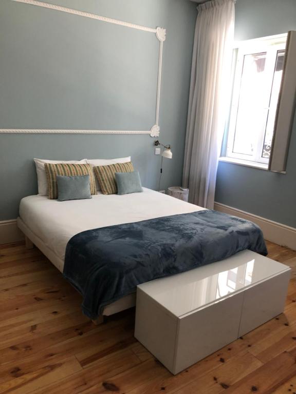 a bedroom with a large bed and a window at Godinho's House in Matosinhos