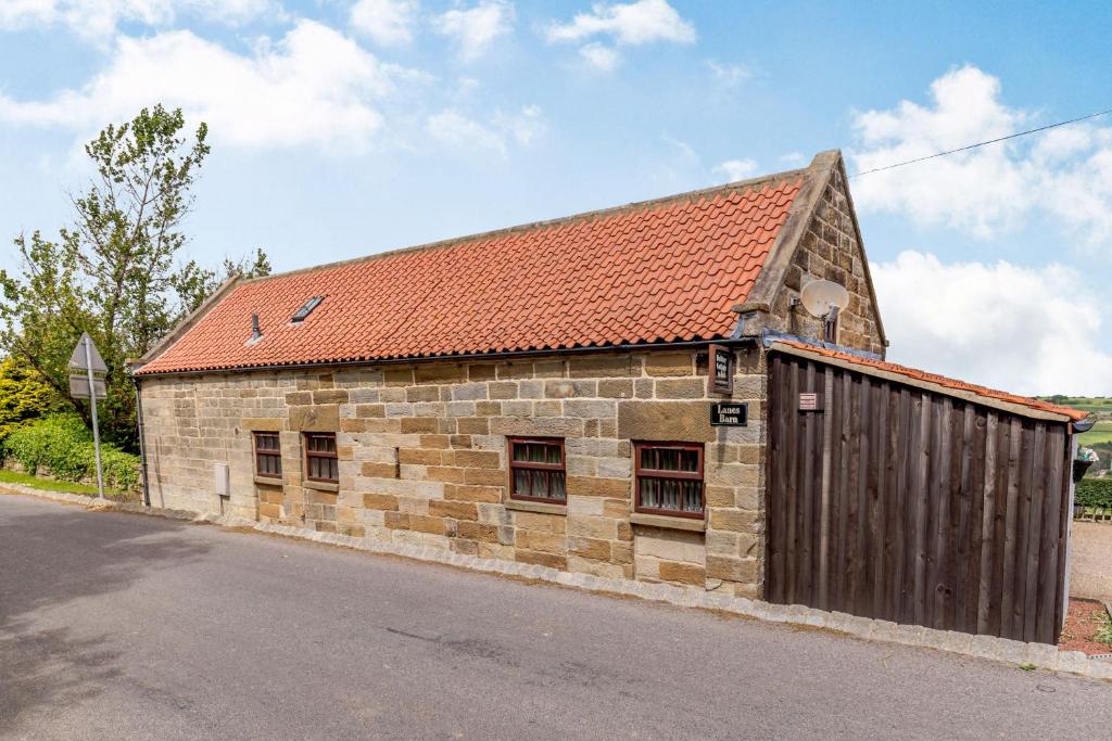 Glaisdale的住宿－Lanes Barn，一座古老的石头建筑,有橙色的屋顶