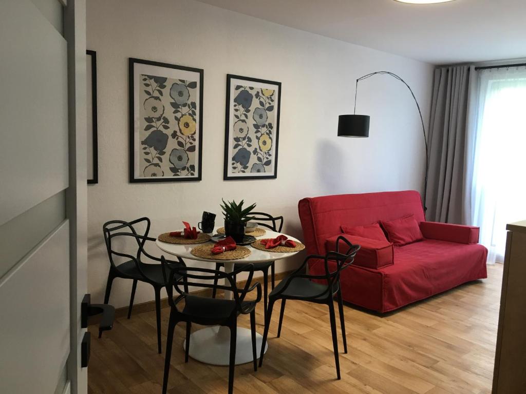 a living room with a table and a red couch at OKO NA ZATOKĘ in Puck