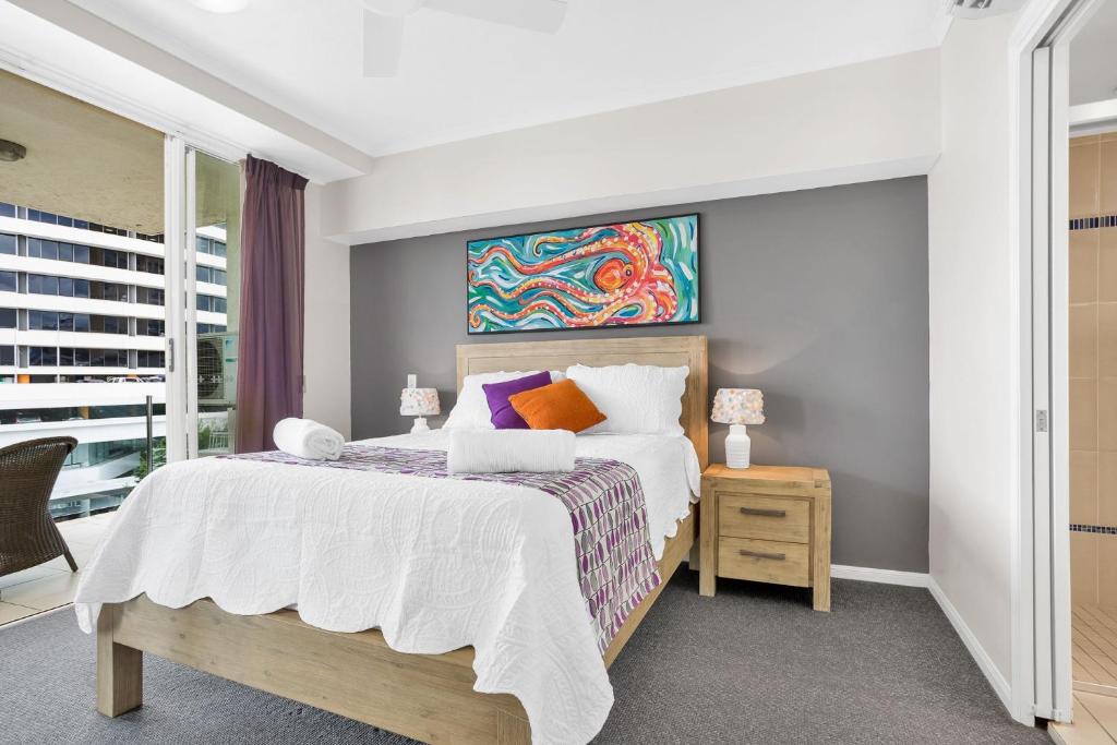 1 dormitorio con 1 cama y una pintura en la pared en City Quays Luxury Dual Key, en Cairns