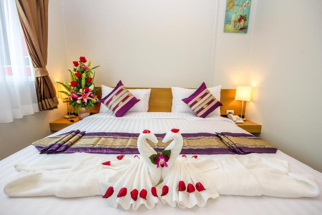 1 dormitorio con 1 cama con 2 cisnes vestidos de blanco en PKL Residence, en Patong Beach