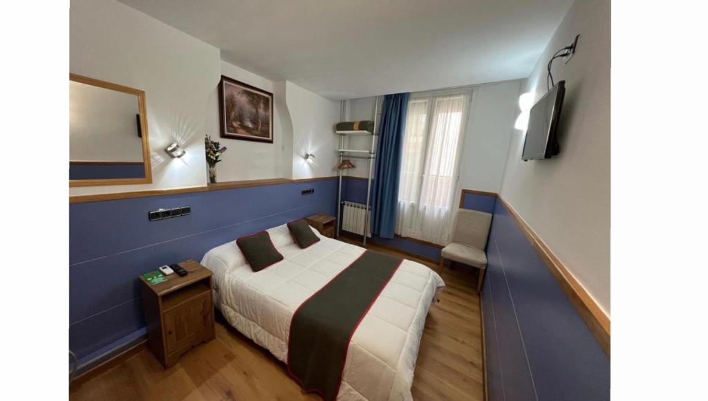 Habitación de hotel con cama y espejo en Pensión Irune by Vivere Stays, en San Sebastián