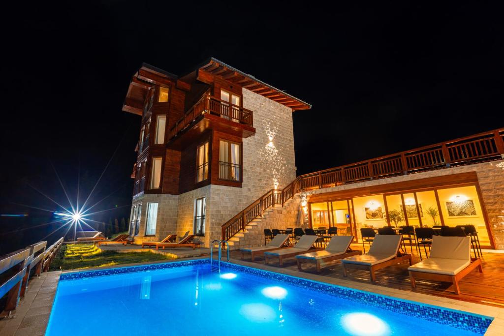 a villa with a swimming pool at night at Hotel NORTH STORY - Luxury Chalet - Apartments & rooms in Žabljak