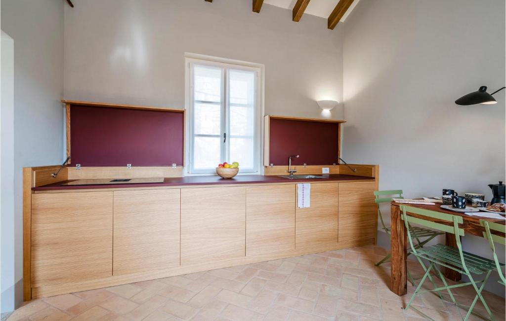 kuchnia z drewnianymi szafkami i oknem w obiekcie Cozy Apartment In Bastia Di Albenga w Albendze