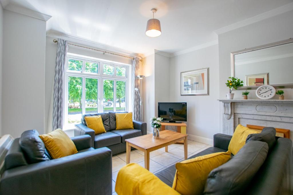 a living room with two couches and a fireplace at 137 - The Townhouse at Gort Na Coiribe By Shortstays in Galway