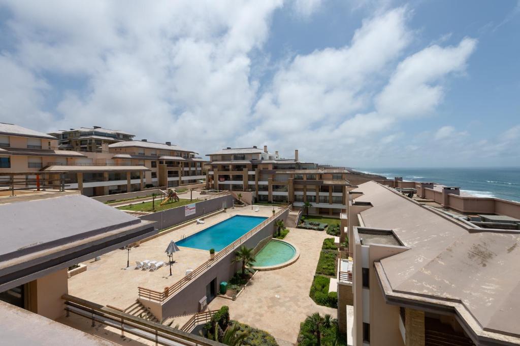 an aerial view of a resort with a swimming pool and the ocean at Appartement 300m2 vue sur océan Prestigia - Plage des nations in Sale