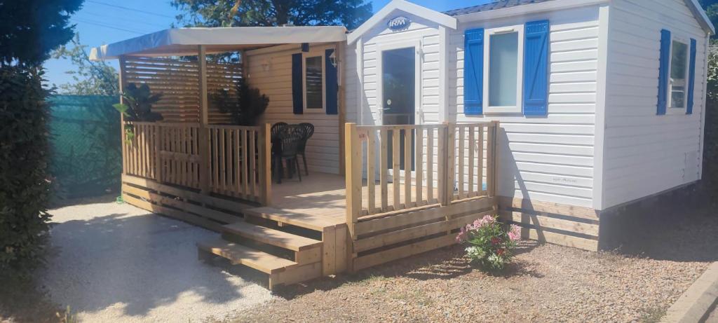 une petite maison avec une terrasse couverte et un escalier en bois dans l'établissement Mobil home 630 camping l'europe, à Vic-la-Gardiole