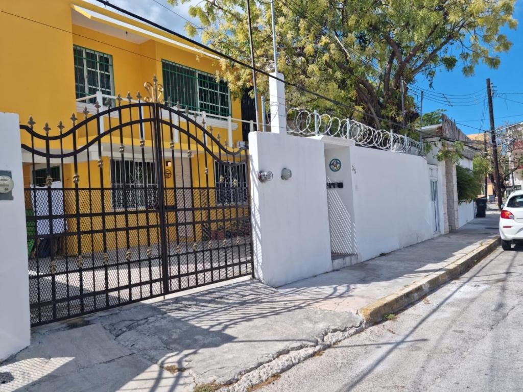 um portão preto e branco em frente a um edifício amarelo em Viento Casa los 4 elementos em Cancún