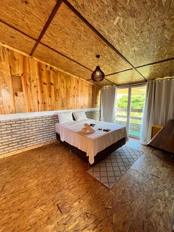 a bedroom with a bed in a room with wooden walls at Villa Flecheiras in Flecheiras