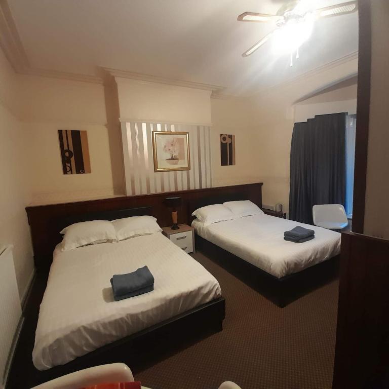 a hotel room with two beds with towels on them at Merginn Guest House in Blackpool