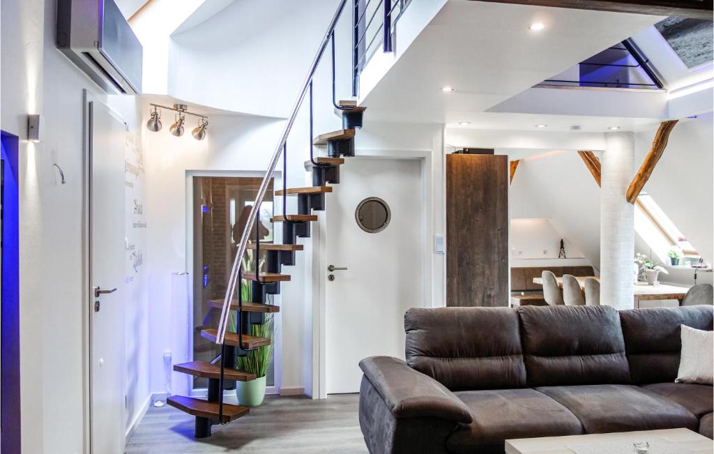 a living room with a couch and a spiral staircase at Nice Apartment In Wurster Nordseeküste in Heuhausen