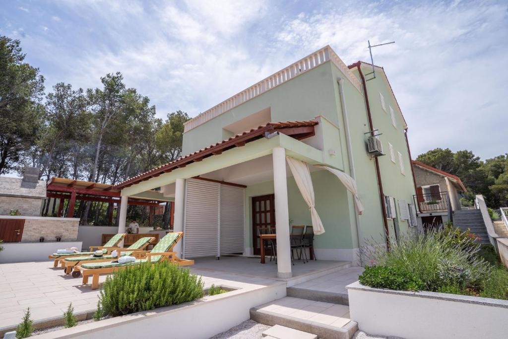 a house with a courtyard and a patio at Villa Kalinić in Milna