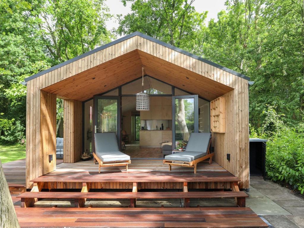 a wooden pavilion with two chairs on a wooden deck at Welcoming holiday home in Wissenkerke with private sauna in Wissenkerke