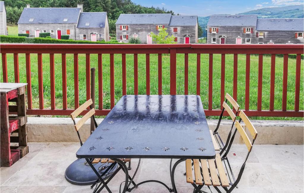 uma mesa e cadeiras sentadas numa varanda com vista para uma casa em Nice Home In La Salvetat-sur-agout With Kitchen em La Salvetat