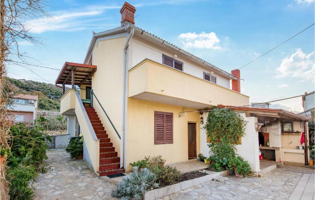 a house with a staircase in front of it at Lovely Apartment In Rab With Kitchen in Rab