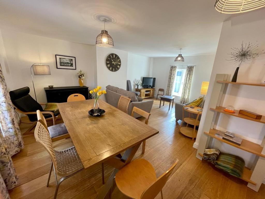 a living room with a table and a dining room at The Knots-Spacious 3 bedroom apartment in Bridport in Bridport