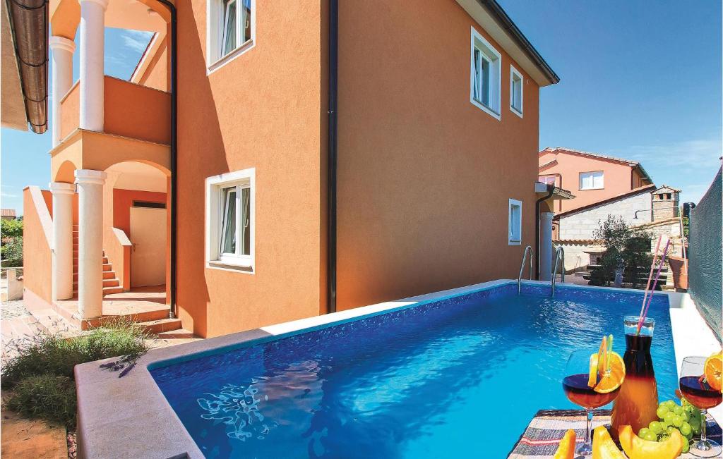 a swimming pool in front of a house at Nice Home In Liznjan With Outdoor Swimming Pool in Ližnjan
