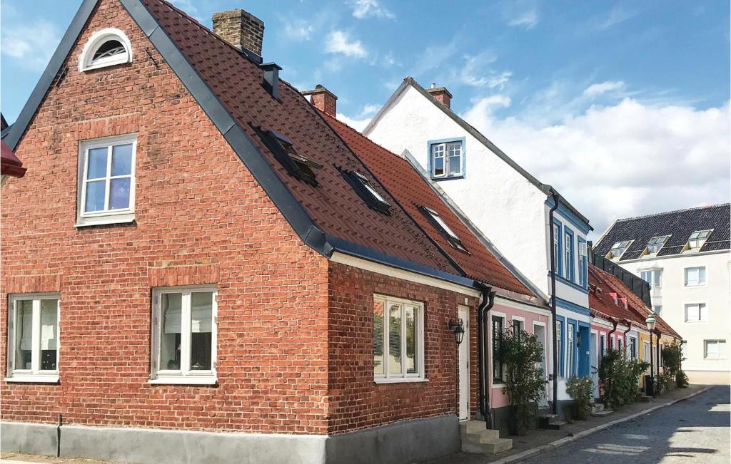 a red brick house with a brown roof on a street at Awesome Home In Ystad With 1 Bedrooms And Wifi in Ystad