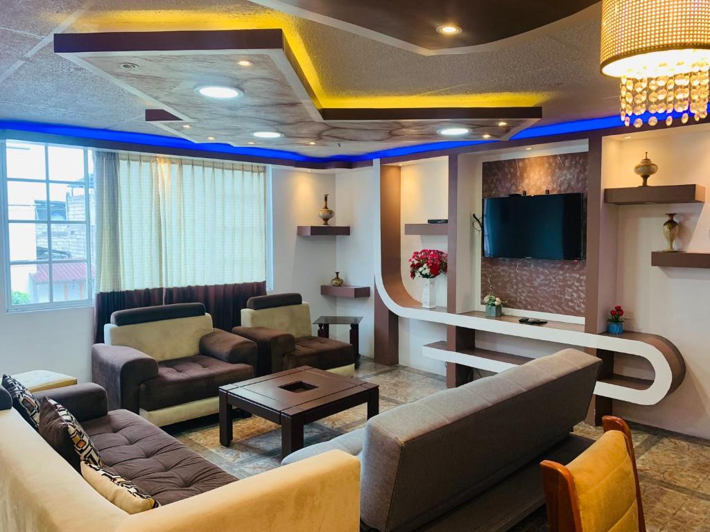 sala de estar con sofá y TV en Confort HOME B Apartamento Claveles, en Baños