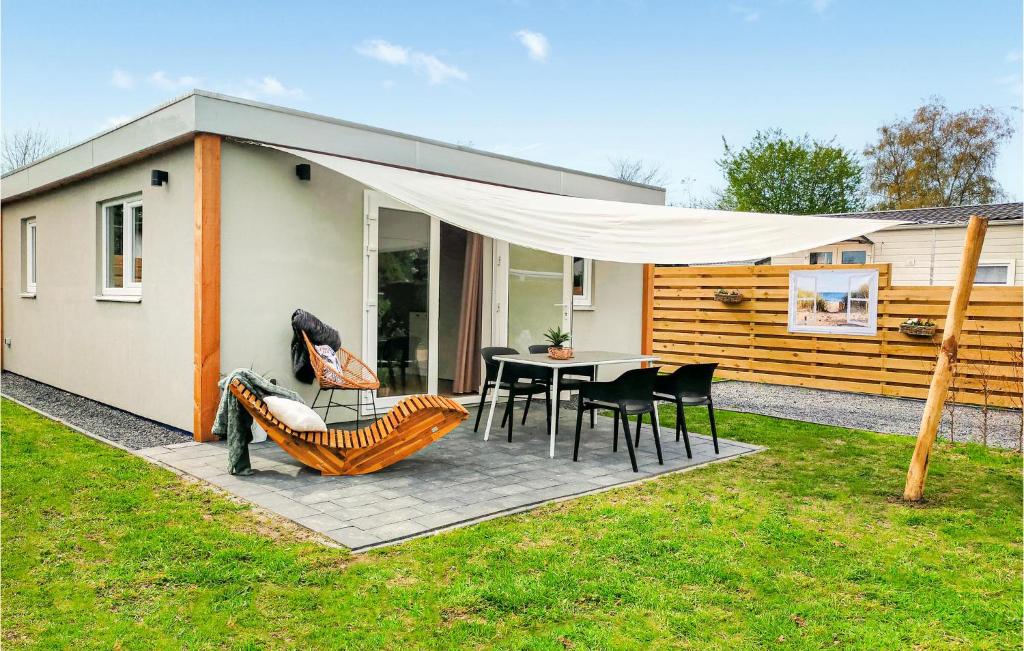 een huis met een patio met een tafel en stoelen bij Gorgeous Home In Heinkenszand With Outdoor Swimming Pool in Heinkensand