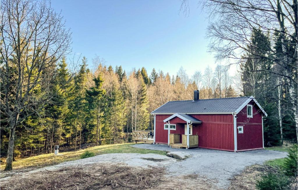 a red shed in the middle of a forest at 2 Bedroom Gorgeous Home In Stillingsn in Kåröd