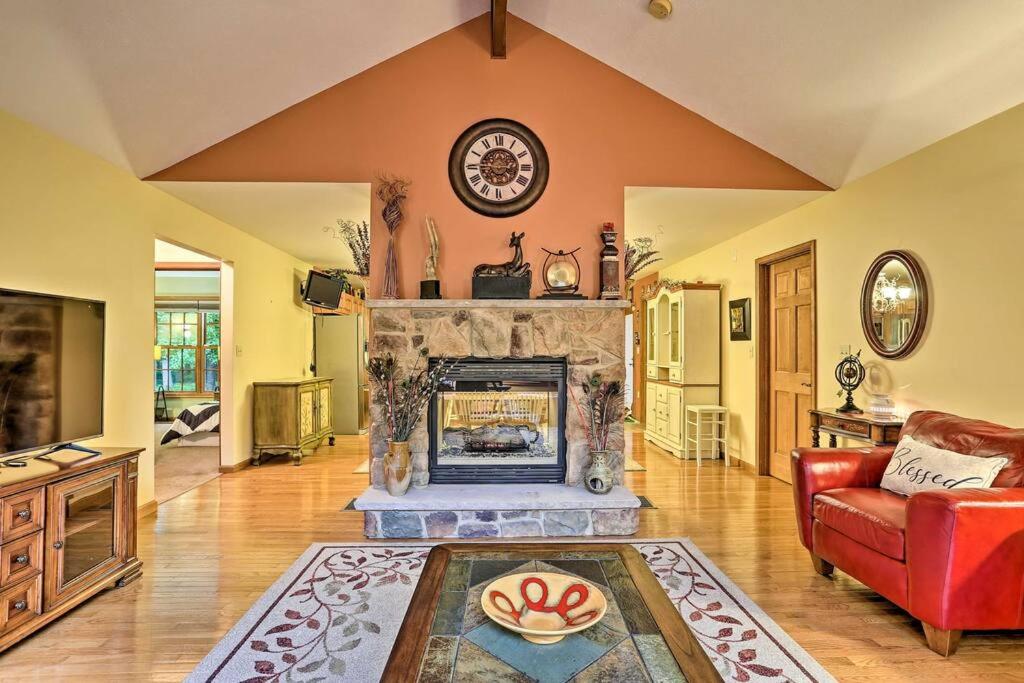 a living room with a fireplace and a red couch at Bushkill Beauty in Bushkill