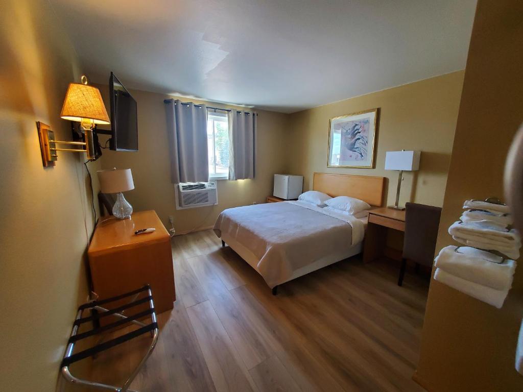 a bedroom with a bed and a desk with a lamp at Alpine Inn in Pagosa Springs