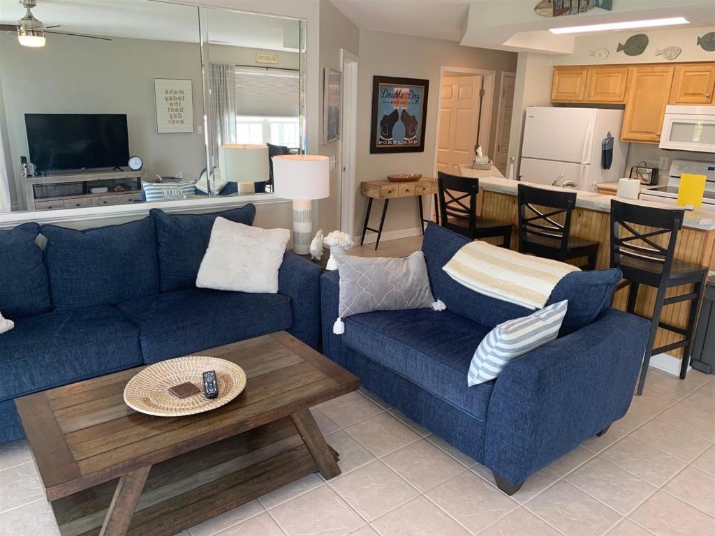a living room with two blue couches and a table at 2504 Commons II in Calabash