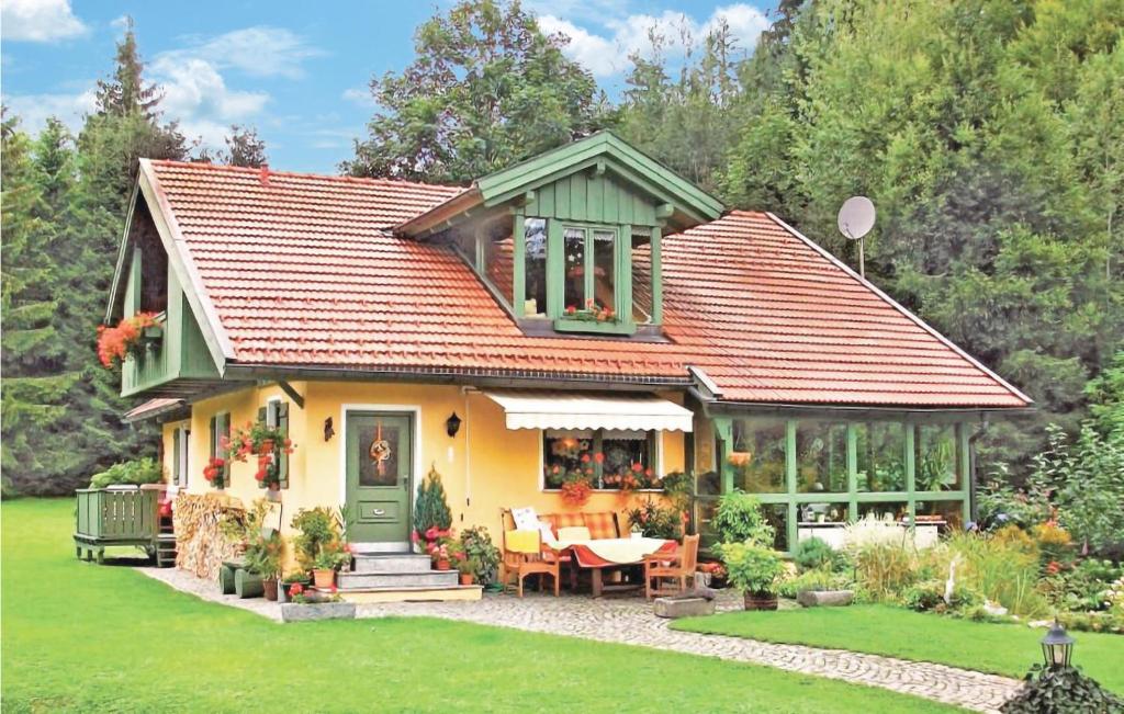 a small yellow house with a green roof at Cozy Home In Bayerisch Eisenstein With Wifi in Regenhütte