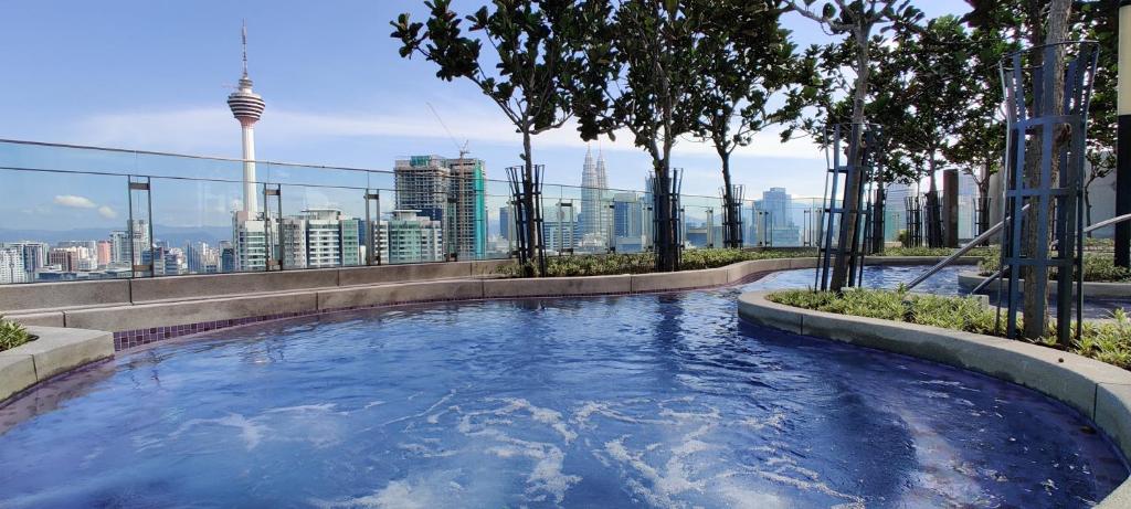 een hot tub bovenop een gebouw met een skyline van de stad bij Infini Suites@ The Robertson Bukit Bintang in Kuala Lumpur