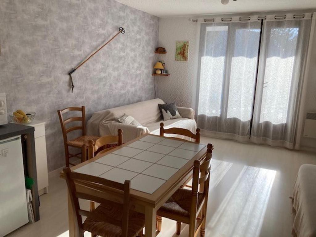 ein Wohnzimmer mit einem Tisch, Stühlen und einem Sofa in der Unterkunft Studio Corrençon-en-Vercors, 1 pièce, 4 personnes - FR-1-515-124 in Corrençon-en-Vercors