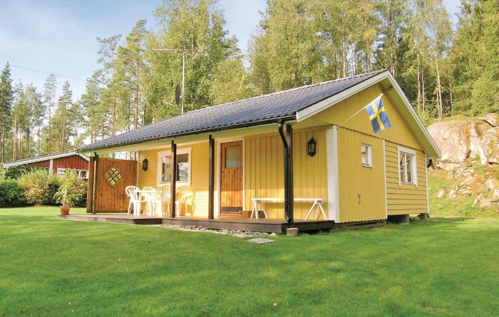 una pequeña casa amarilla con un gran patio en Nice Home In Svenljunga With House Sea View, en Svenljunga