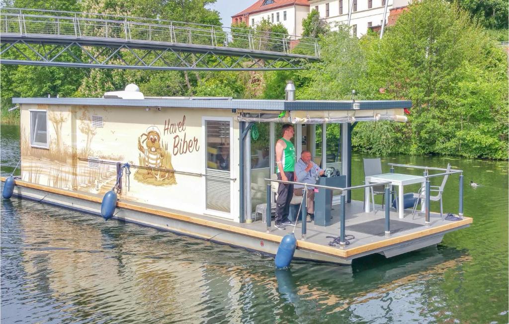 two people standing on a house boat on the water at Gorgeous Ship In Havelsee With House Sea View in Kützkow