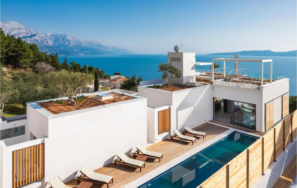 an aerial view of a house with a swimming pool and the ocean at Stunning Home In Omis With Kitchen in Omiš