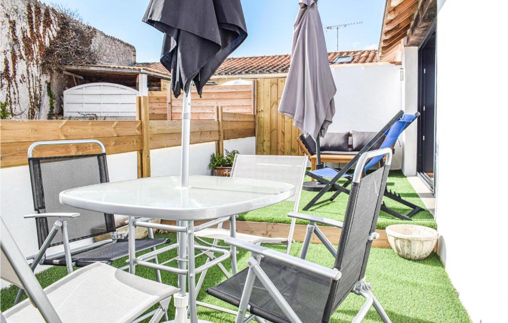 a patio with a table and chairs and an umbrella at 1 Bedroom Awesome Apartment In Noirmoutier-en-lle in Noirmoutier-en-l'lle