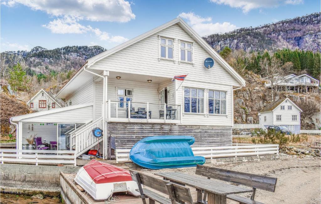 a house with a boat sitting on a table in front of it at Amazing Home In Vanvik With Kitchen in Sand