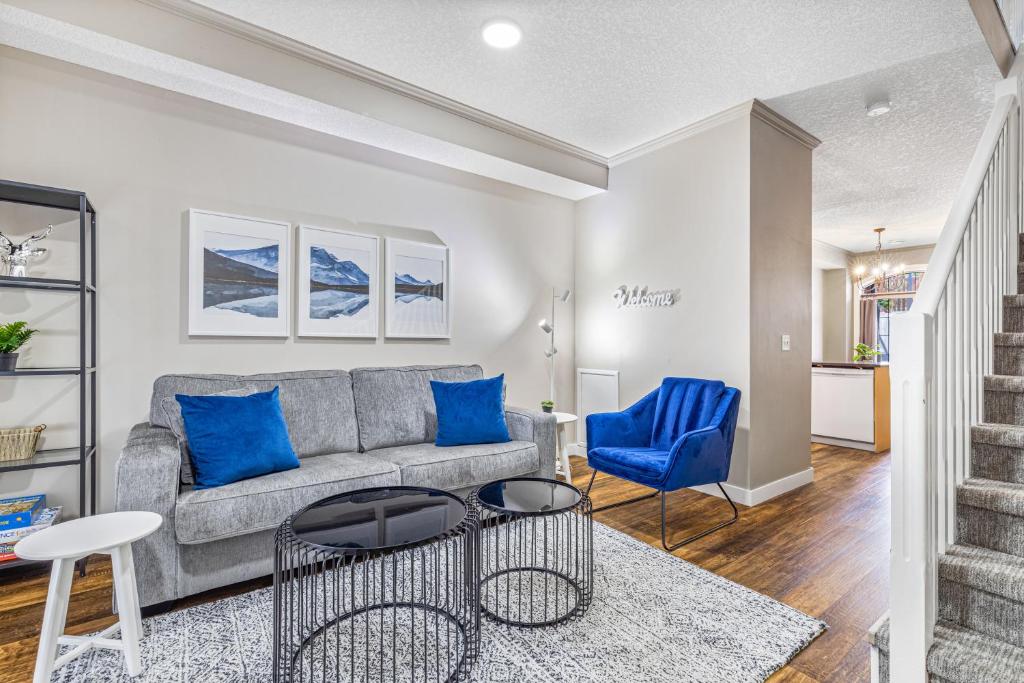 uma sala de estar com um sofá cinzento e cadeiras azuis em Mystic Chalet hosted by Fenwick Vacation Rentals em Canmore