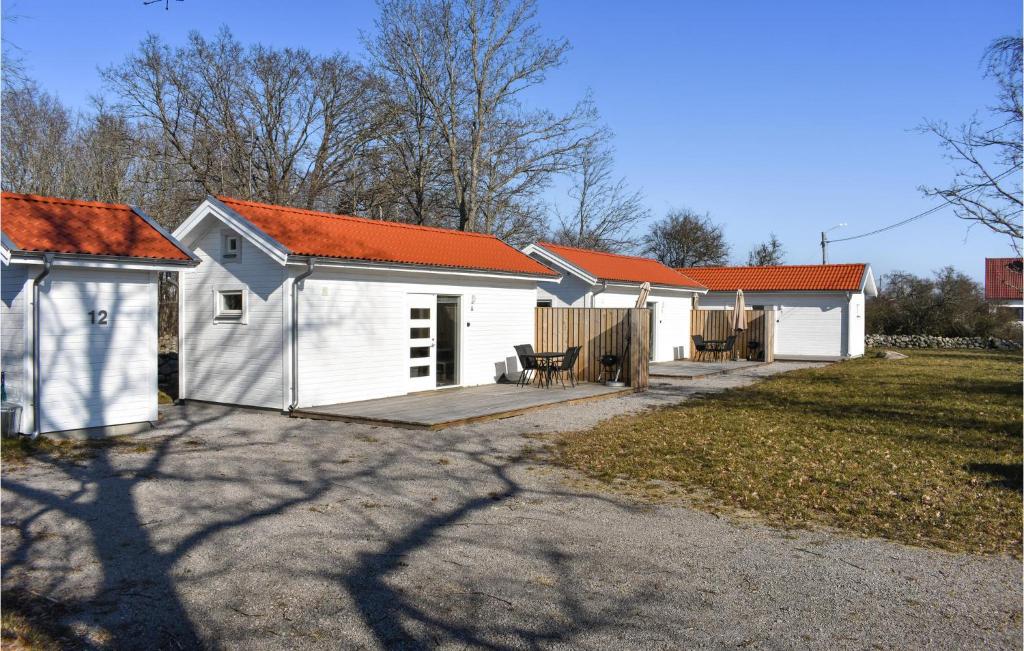 eine Reihe weißer Gebäude mit orangefarbenen Dächern in der Unterkunft Stunning Home In Hassl With Kitchen in Hasslö