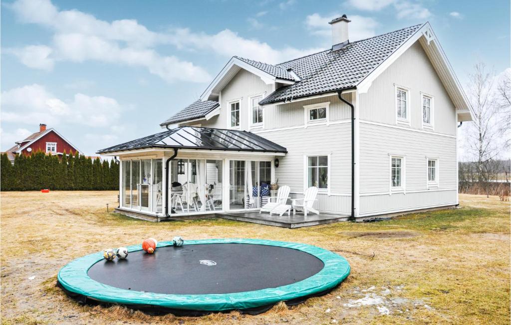 a white house with a trampoline in the yard at Beautiful Home In Karlstad With Wifi And 4 Bedrooms in Karlstad