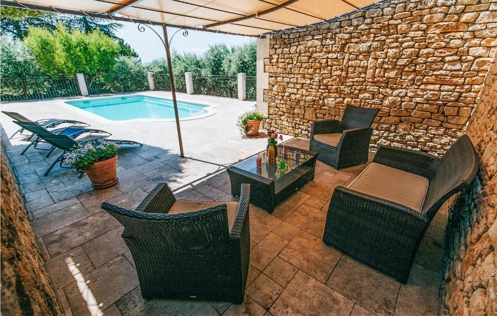 an outdoor patio with chairs and a swimming pool at Gorgeous Home In Lioux With Wifi in Lioux