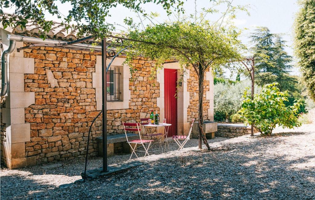 a brick house with a table and a red door at Gorgeous Home In Lioux With Wifi in Lioux