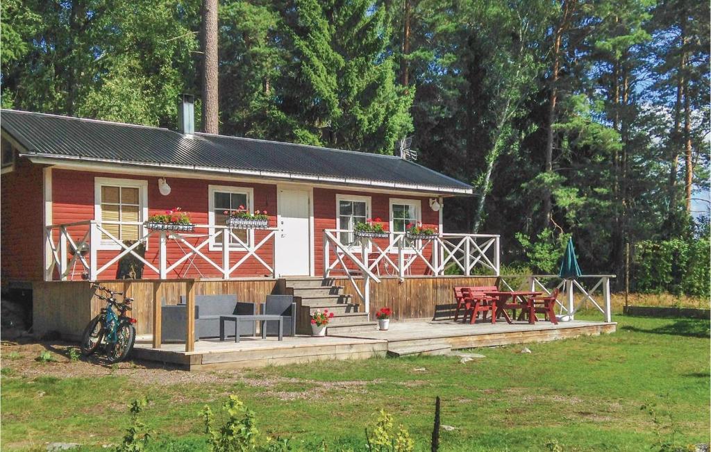 Casa roja y blanca con terraza y mesas en Gorgeous Home In Blsta With Kitchenette en Bålsta