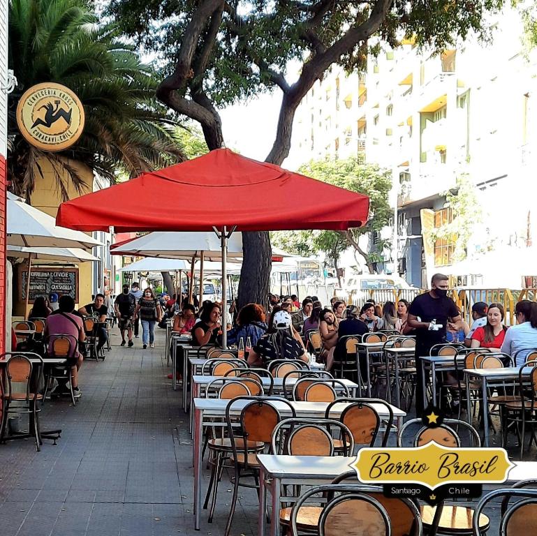a group of tables and chairs with a red umbrella at Casa dos Leones in Santiago