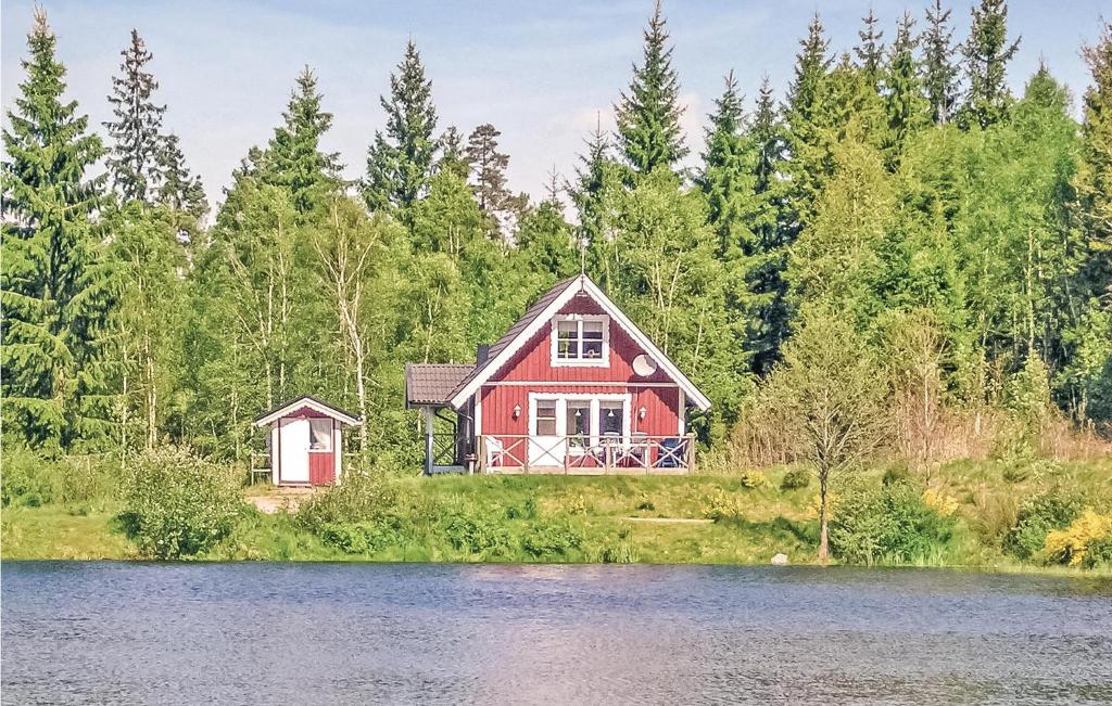 ein rotes Haus am Ufer eines Sees in der Unterkunft 3 Bedroom Cozy Home In Lngaryd in Långaryd