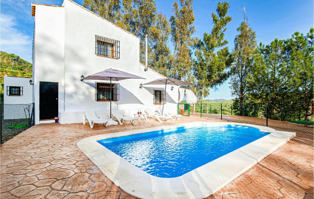Villa con piscina frente a una casa en Pet Friendly Home In Colmenar With Kitchen, en Colmenar