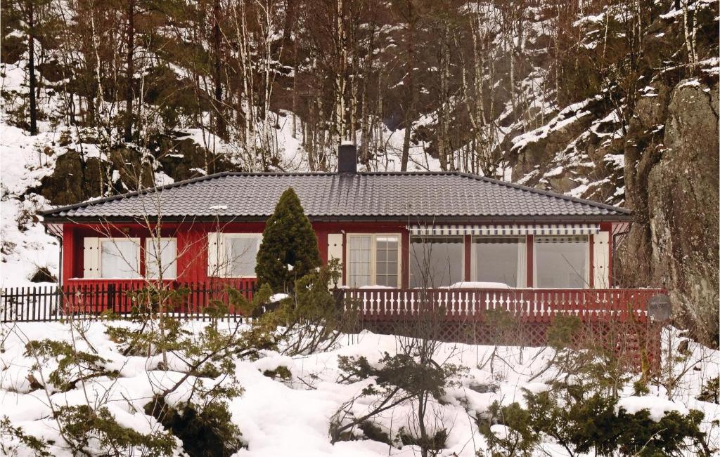 a small red house in the snow with trees at Gorgeous Home In Kvinlog With Kitchen in Kvinlog